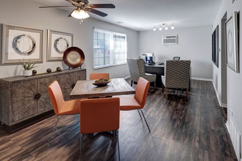 A dining room with a wooden table and orange chairs.