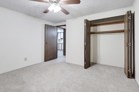 A room with a ceiling fan and a door.