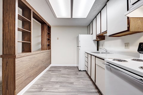 A kitchen with white appliances and wooden cabinets.