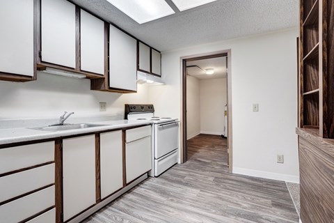 A kitchen with white cabinets and a white sink.