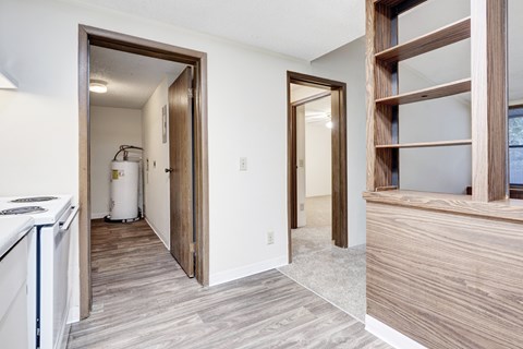 A kitchen with a white dishwasher and a wooden floor.