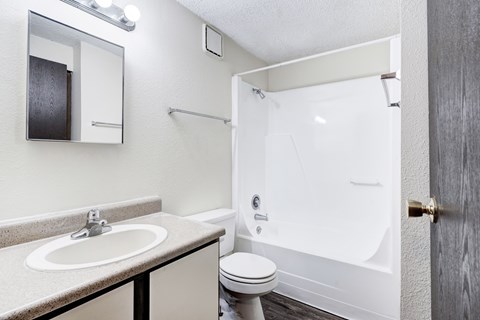 A bathroom with a sink, toilet, and shower.