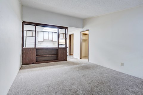 A room with a carpeted floor and a wooden cabinet with a glass door.