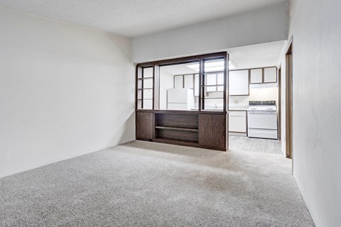 A room with a carpeted floor and a wooden cabinet with glass doors.