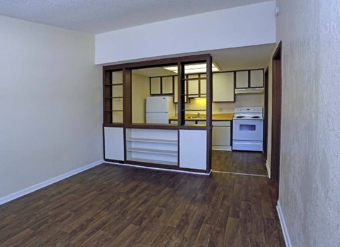 A kitchen with white cabinets and a wooden floor.