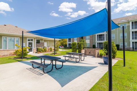 A blue shade structure is over a picnic table.
