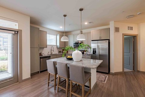A kitchen with a table and chairs in the middle of the room.