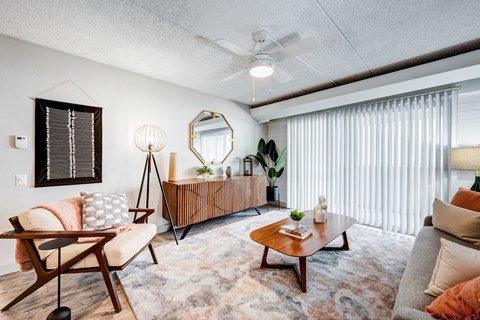 A living room with a wooden chair and a mirror on the wall.