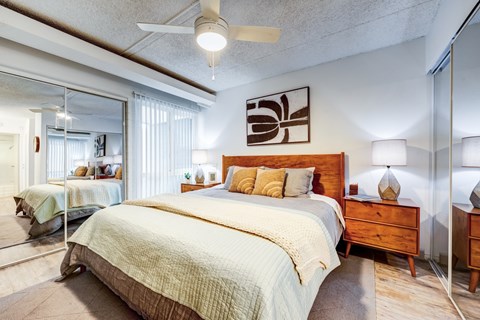 A bedroom with a large bed and a ceiling fan.