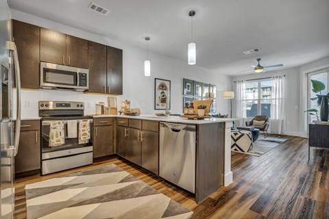 A modern kitchen with dark wood cabinets and stainless steel appliances.