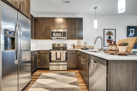 A modern kitchen with stainless steel appliances and wooden cabinets.