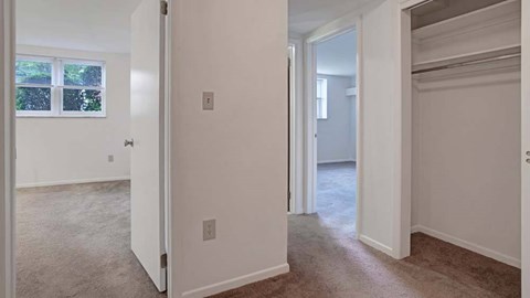 A white door is open to a room with a carpeted floor.