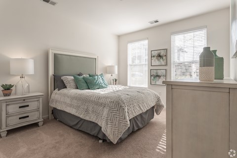 A bedroom with a bed, nightstand, and a cabinet.