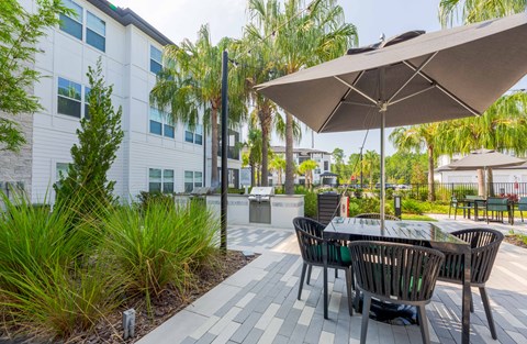 A patio with a table and chairs under an umbrella.