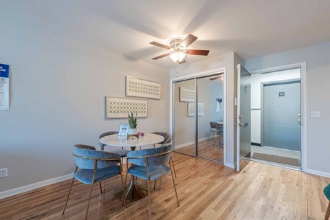 A dining room with a table and chairs and a ceiling fan.