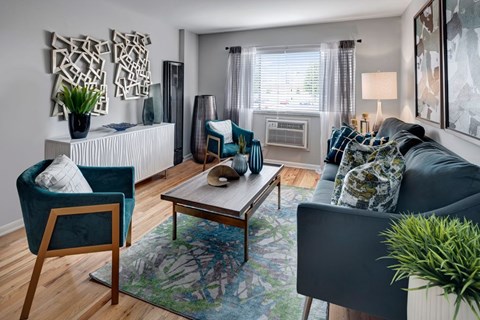 A living room with a grey couch, a blue chair, and a wooden coffee table.