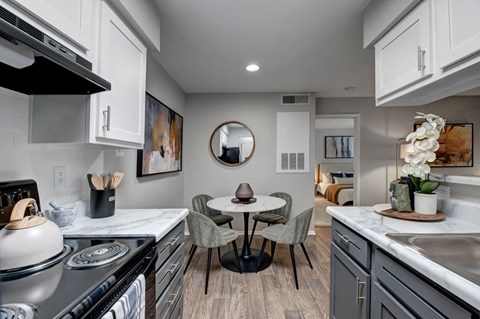 A modern kitchen with a round table and chairs in the middle.