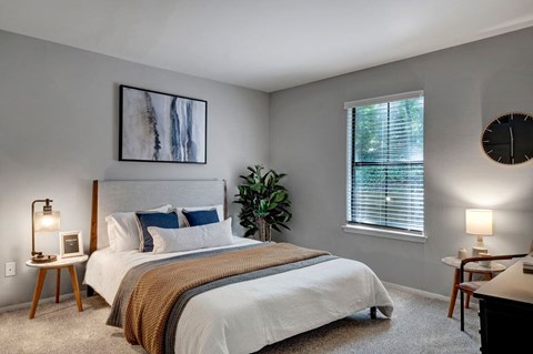 A bedroom with a large bed and a painting on the wall.