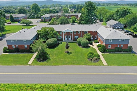 A large red building with a green lawn in front.