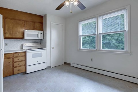 A kitchen with white appliances and wooden cabinets.