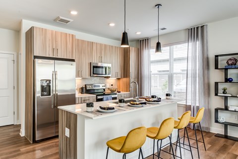 A modern kitchen with wooden cabinets and a white island.
