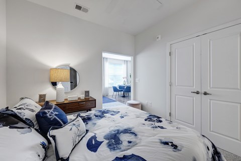 A bedroom with a large bed and a mirror on the wall.