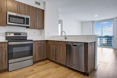 A modern kitchen with wooden cabinets and stainless steel appliances.