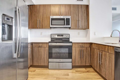 A modern kitchen with wooden cabinets and stainless steel appliances.