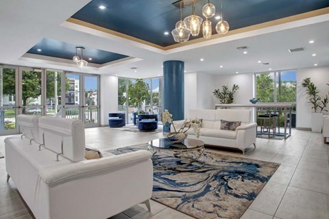 A modern living room with a white sofa and a blue rug.