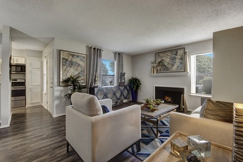 A living room with a beige couch, a coffee table, and a fireplace.