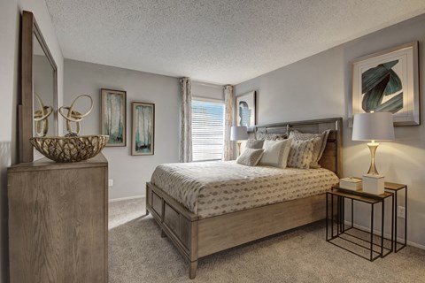 A bedroom with a large bed and a wooden dresser.