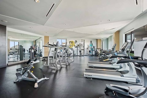 A gym with treadmills, exercise bikes, and other equipment.