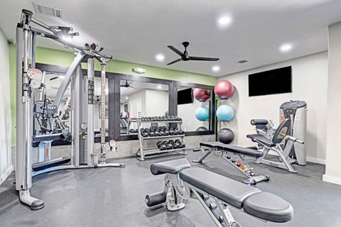 A gym with a variety of equipment including a leg press machine.