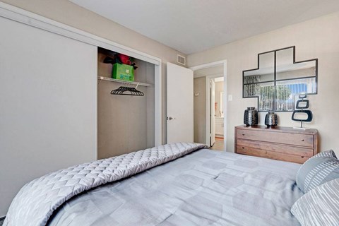 A bedroom with a large bed and a wooden dresser.