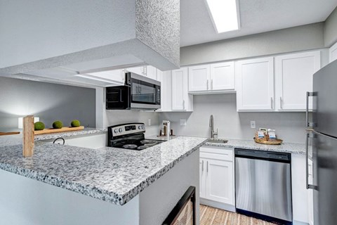 A kitchen with granite countertops and stainless steel appliances.