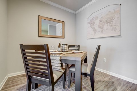 A dining room with a wooden table and chairs.
