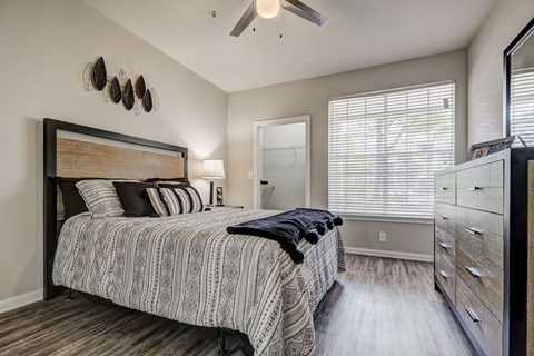 A bedroom with a large bed and a ceiling fan.