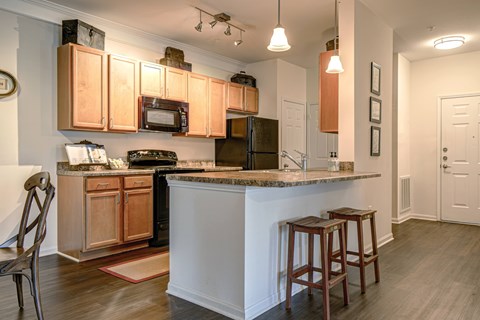 A kitchen with wooden cabinets and a white island.
