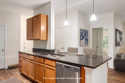 A kitchen with brown cabinets and a black countertop.