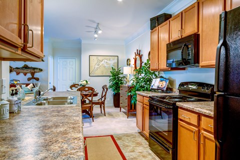 A kitchen with wooden cabinets and a granite countertop.