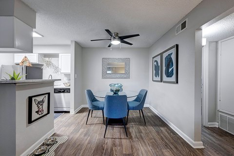 A dining room with a blue table and chairs.