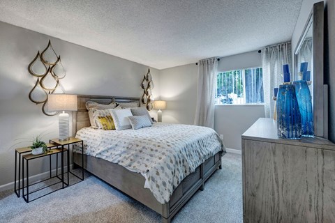 A bedroom with a large bed and a wooden dresser.