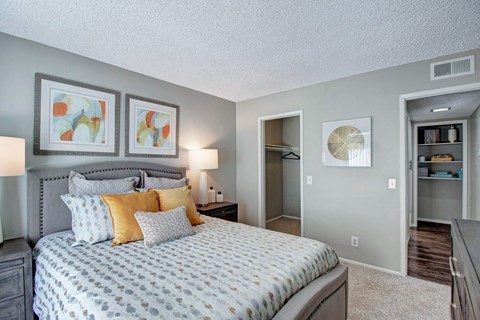A bedroom with a large bed and a painting on the wall.