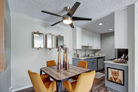A modern dining room with a wooden table and orange chairs.