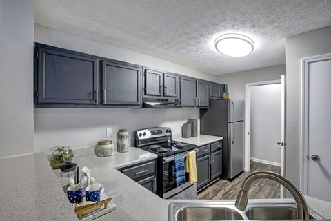 A kitchen with a stove, oven, and refrigerator.