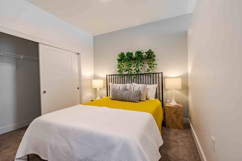 A bedroom with a white bedspread and a yellow bed.