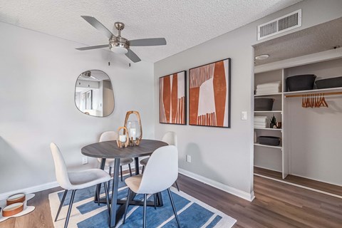 A dining room with a round table and chairs.