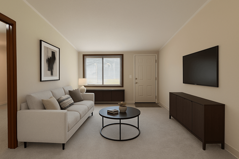 A living room with a couch, coffee table, and a flat screen TV mounted on the wall.