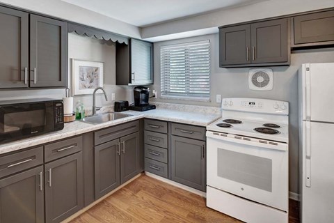 A kitchen with a white stove top oven and a white refrigerator.