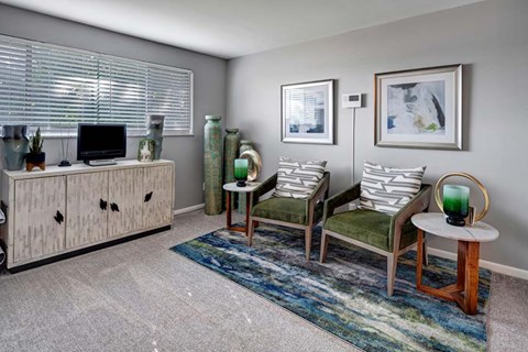 A living room with a green chair and a white table.